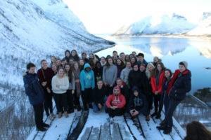 Bilde av en gruppe elever på et utkikkspunkt med fjord og fjell i bakgrunnen - Klikk for stort bilde